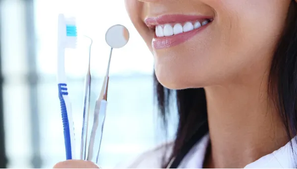 Vrouw met een stralende glimlach houdt tandenborstels vast